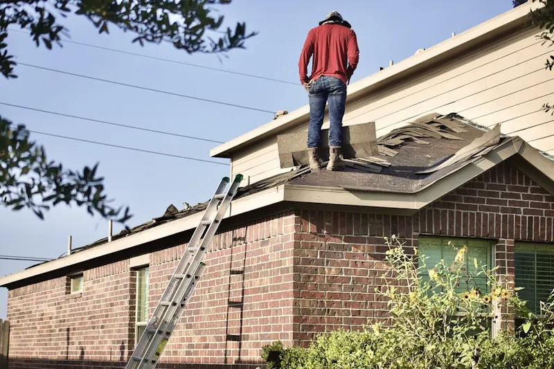 Professional roofer working on a residential roof in Totoket
